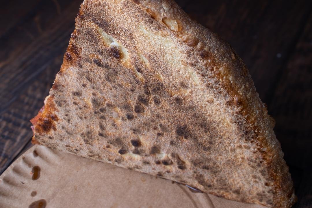 Classic NY-style pizza slice with perfect char